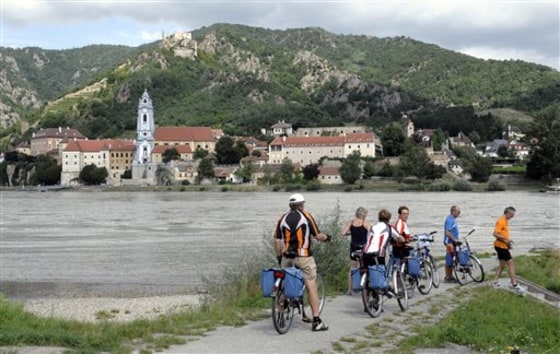 Bicyclists take a break Aug. 19 in Rossatz, in the Lower Austrian province along the Danube river. Durnstein village is seen in the background. With paths that wind through vineyards, fruit groves and fairy tale villages overlooking the Danube, the Alpine republic's world famous Wachau region is best explored by bike.